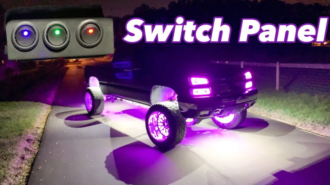 A black lifted truck illuminated by bright purple LED underglow and wheel lights at night, parked on a driveway. In the top left corner, an inset shows a three-button switch panel with illuminated blue, green, and red buttons. The words 'Switch Panel' appear in bold white and purple letters above the truck.